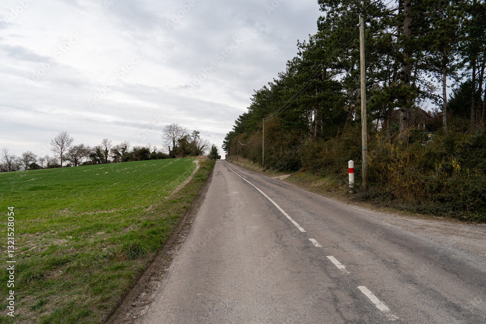 Scenic rural road winding through La Roche-Guyon commune in Pontoise district, revealing nature's beauty in a tranquil setting Scenic rural road winding through La Roche-Guyon commune in Pontoise district, revealing nature's beauty in a tranquil setting