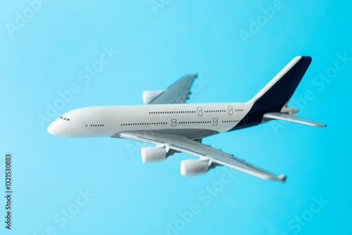 Plane model in air on light blue background, closeup