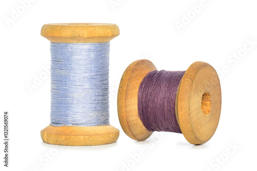 Old retro sewing blue purple colored thread spools isolated white background