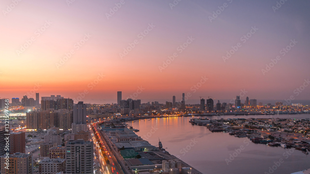 Fototapeta premium Cityscape of Ajman from rooftop day to night timelapse after sunset.