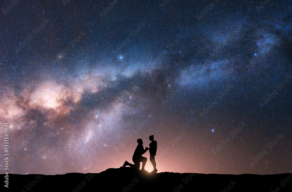 Fototapeta premium Milky Way with silhouettes of a man making marriage proposal to his girlfriend and starry sky at night. Silhouette of lovers. Couple, relationship. Milky way with people. Universe. Space background