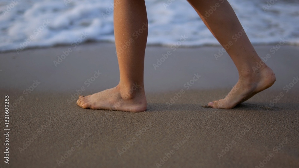 Barefoot child walks along the seashore, enjoying the gentle waves and soft sand between their toes, creating a peaceful and carefree summer scene Barefoot child walks along the seashore, enjoying the gentle waves and soft sand between their toes, creating a peaceful and carefree summer scene