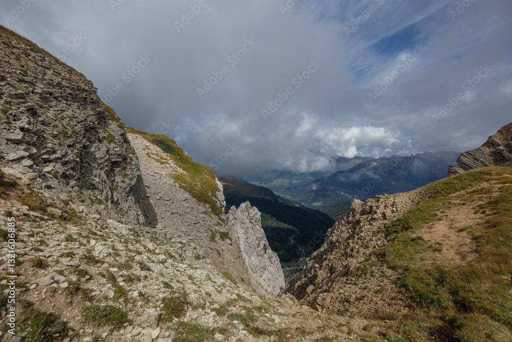Scenic view from Seceda in the Dolomites showcasing dramatic cliffs and cloudy skies Scenic view from Seceda in the Dolomites showcasing dramatic cliffs and cloudy skies