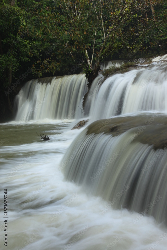 Fototapeta premium Pa La Tha Waterfall is a beautiful limestone waterfall. Its highlight is the waterfall's long width, clearly descending into 3 levels. It is most beautiful during the rainy season. Umphang ,THAILAND