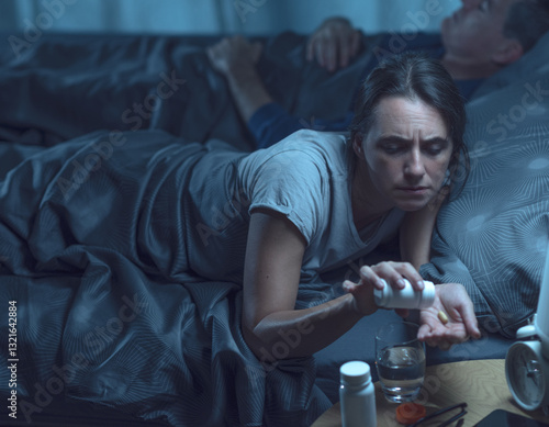 Woman suffering from insomnia and taking pills