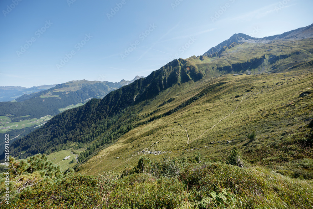 Scenic view of the Ahorn mountain range in Mayrhofen, Austria during a clear summer day with lush green valleys and towering peaks Scenic view of the Ahorn mountain range in Mayrhofen, Austria during a clear summer day with lush green valleys and towering peaks
