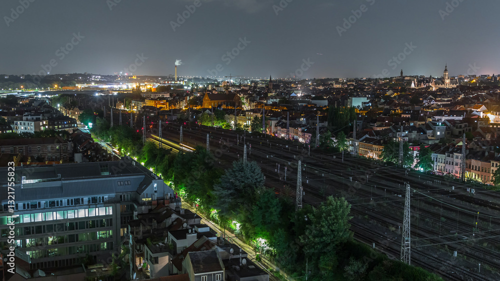 Fototapeta premium Aerial night timelapse of Brussels North station railway tracks with trains arriving and departing. Belgium