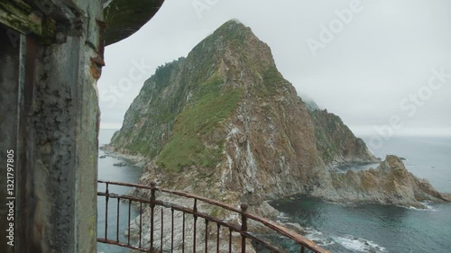 Sakhalin, Aniva lighthouse. Water, mountains and birds all around. Cloudy weather