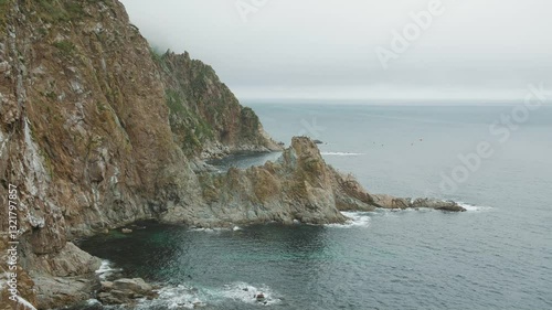 Sakhalin, Aniva lighthouse. Water, mountains and birds all around. Cloudy weather