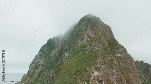 Sakhalin, Aniva lighthouse. Water, mountains and birds all around. Cloudy weather