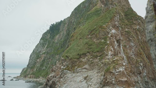 Sakhalin, Aniva lighthouse. Water, mountains and birds all around. Cloudy weather