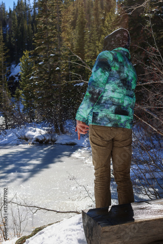 Man skipping rocks across pond in the Rocky Mountains of Colorado