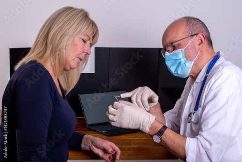 Doctor explains the procedure of inserting hearing aids for a patient's hearing loss, at a audiology hospital appointment. Medical clinic. ENT exam. 