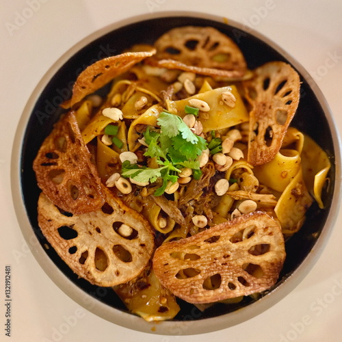 Delicious shredded chicken pasta with lotus root chips displayed in Malaysia