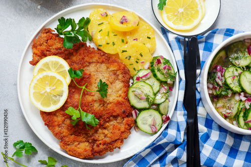 Canvas Print Traditional Viennese schnitzel on a plate with cucumber and potato salad