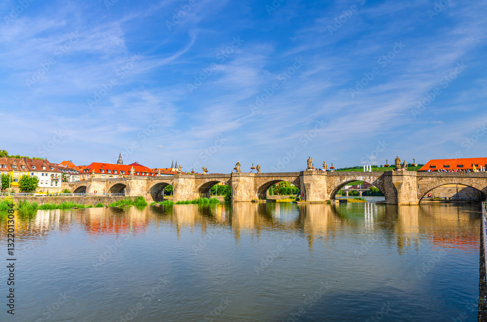 Obraz premium Old Main Bridge across Main river Alte Mainbrucke with statues of saints in Wurzburg old town altstadt in sunny summer day, Wurzburg city historical center Mitte, Lower Franconia region, Germany