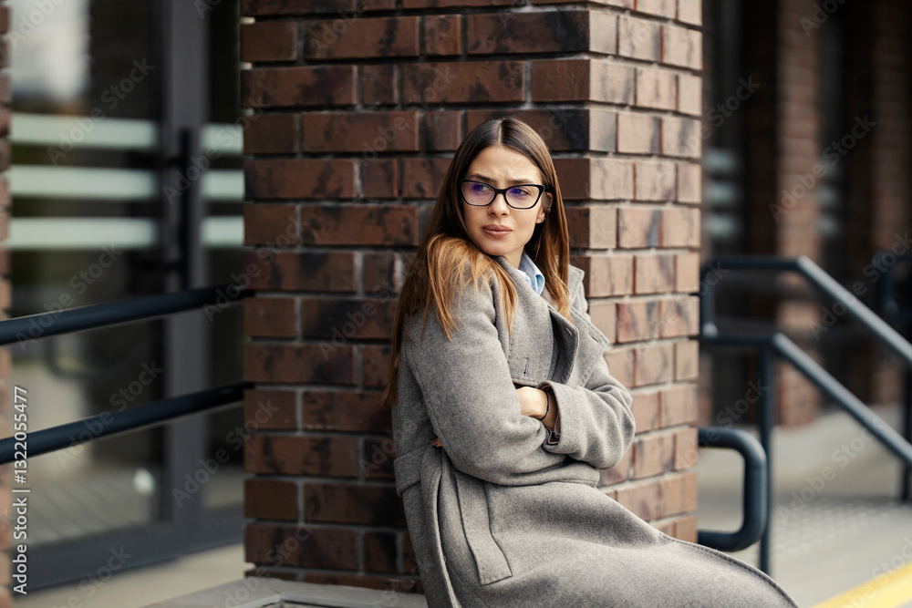 Fototapeta premium Young sad woman sitting on city street alone and depressed.