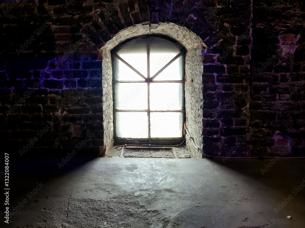 Obraz premium Old stone wall with a vintage window casting a soft light. The contrast between dark textures and illuminated glass creates a moody atmosphere.