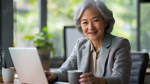 Confident Asian businesswoman at modern office desk celebrating success photo