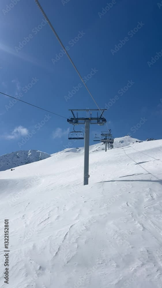 Ski lift over the slopes of Courchevel ski resort by winter Ski lift over the slopes of Courchevel ski resort by winter