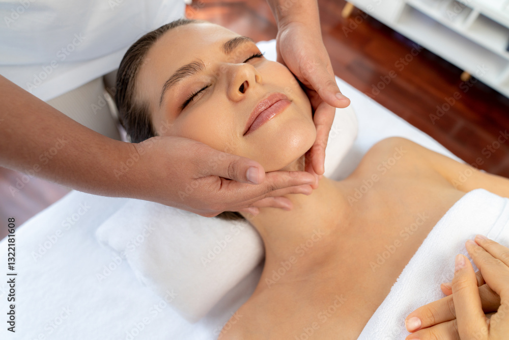 Caucasian woman enjoying relaxing anti-stress head massage and pampering facial beauty skin recreation leisure in dayspa modern light ambient at luxury resort or hotel spa salon. Quiescent Caucasian woman enjoying relaxing anti-stress head massage and pampering facial beauty skin recreation leisure in dayspa modern light ambient at luxury resort or hotel spa salon. Quiescent