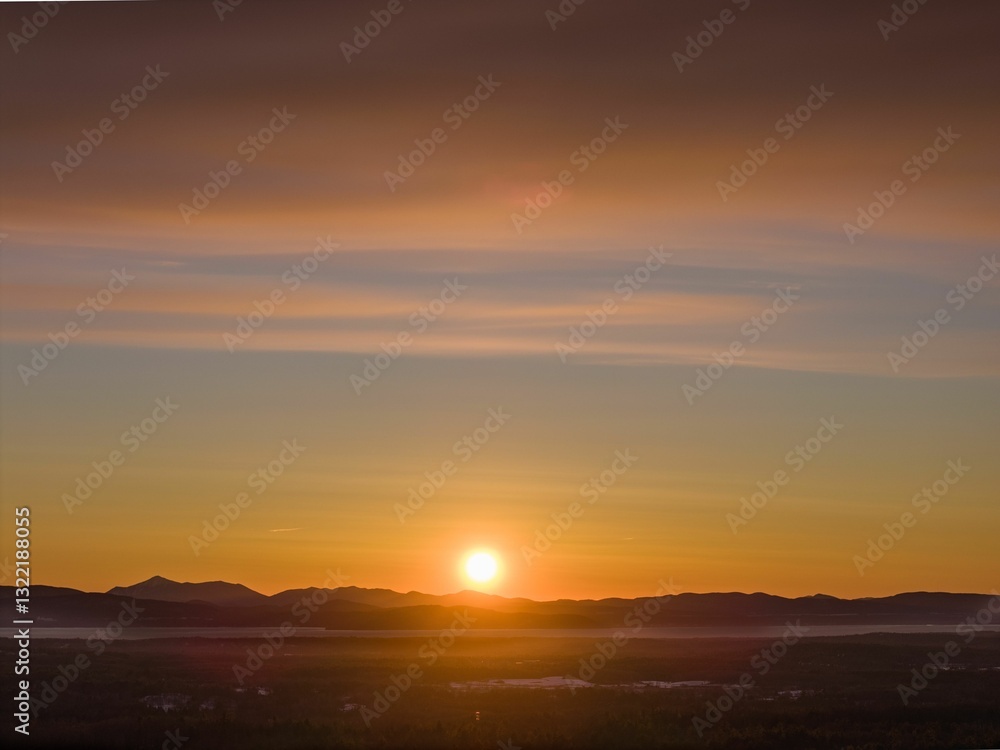 Sunrise over a mountain range with a vibrant orange sky, capturing the beauty of nature Sunrise over a mountain range with a vibrant orange sky, capturing the beauty of nature