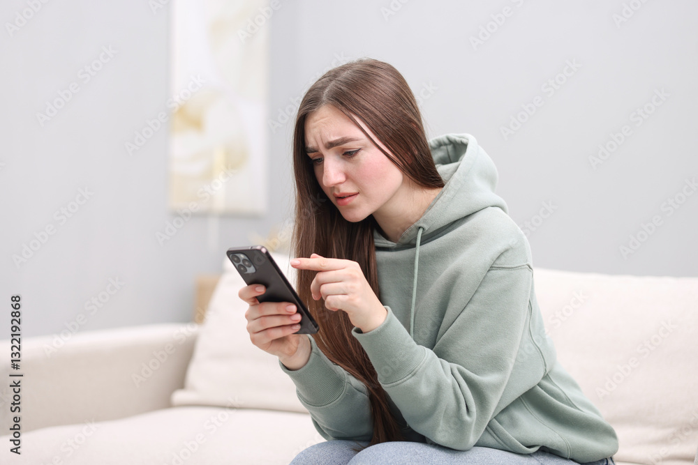 Depressed woman calling hotline for mental health help on sofa at home Depressed woman calling hotline for mental health help on sofa at home