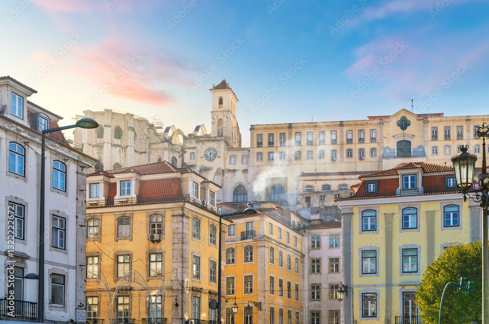Fototapeta premium Early sunset view of Carmo Convent, or Convent of our Lady of Carmel and clock tower seen from Rossio Square in the historic center of Lisbon, Portugal. 
