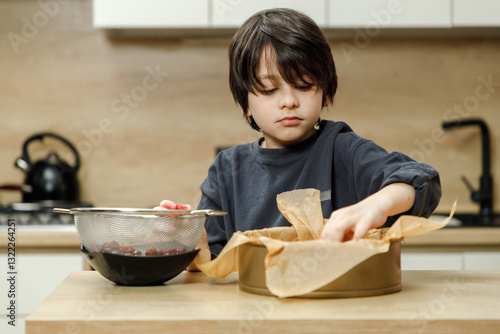Mother and son are preparing a cherry cake together