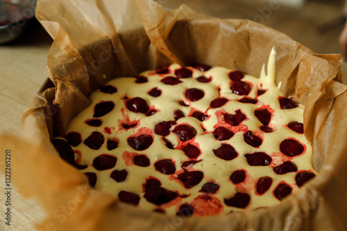 Mother and son are preparing a cherry cake together