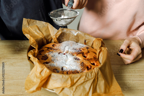 Mother and son are preparing a cherry cake together