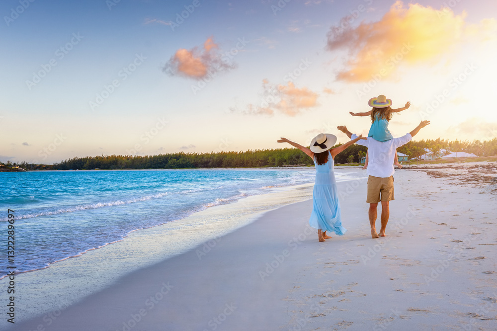 A happy family on summer holidays walks on a beautiful, tropical beach during sunset time