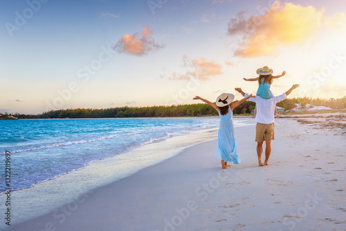 Obraz na płótnie A happy family on summer holidays walks on a beautiful, tropical beach during sunset time w salonie