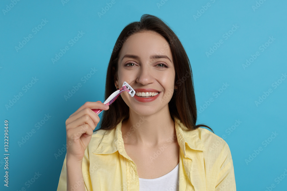 Happy woman shaving her mustache with razor on light blue background Happy woman shaving her mustache with razor on light blue background