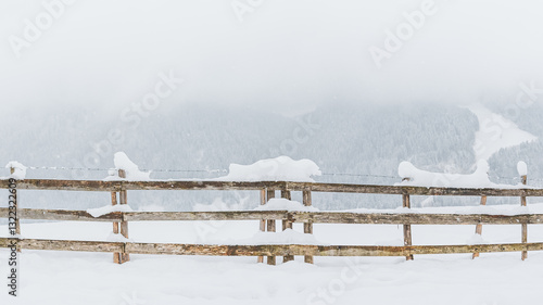 Obraz na płótnie Snow-covered wooden fence on a mountain pasture. Winter landscape on a mountain hiking trail on a cloudy and foggy day. w salonie