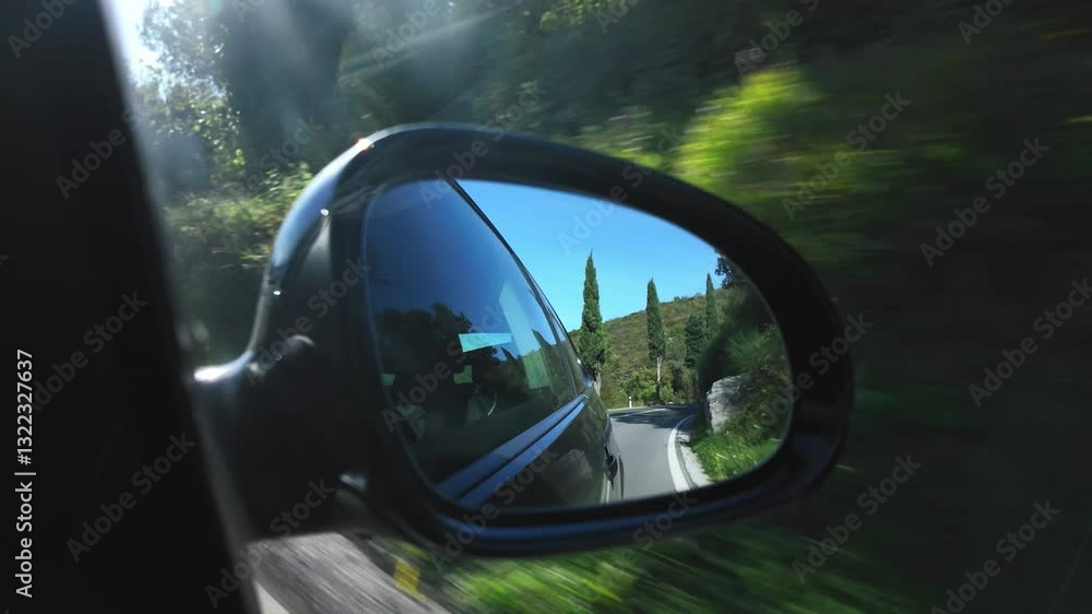 Driving along along the coast of the Adriatic Sea with mediterranean vegetation on a sunny day. Side mirror view of a driving car with sun glare. Amazing beach road in Istria Peninsula. Driving along along the coast of the Adriatic Sea with mediterranean vegetation on a sunny day. Side mirror view of a driving car with sun glare. Amazing beach road in Istria Peninsula.