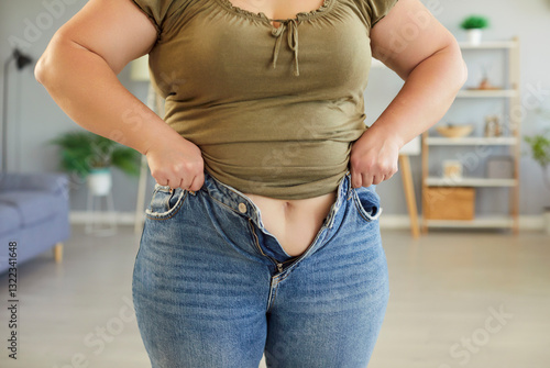 Foto Woman who has gained weight is trying to put on jeans