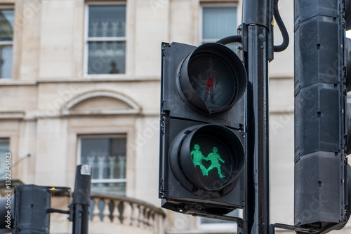 Wallpaper Mural A pedestrian traffic light in London displays a green signal with two walking figures. A historic building is visible in the background. Torontodigital.ca