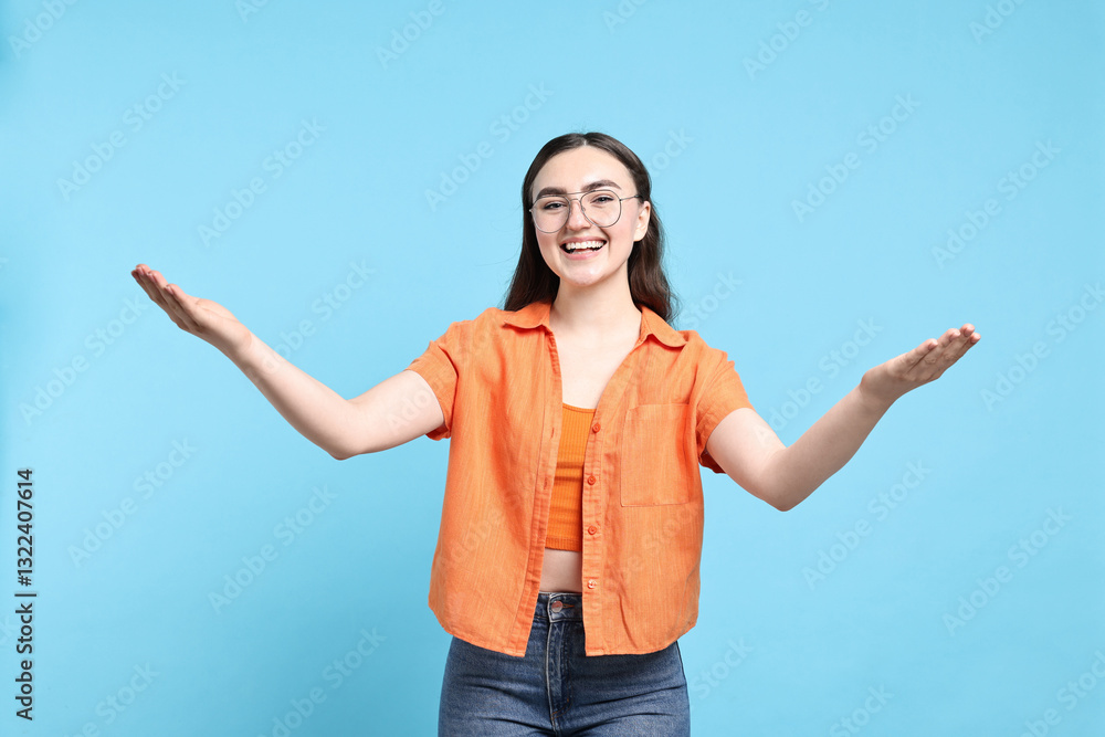 Happy woman welcoming friends or guests on light blue background Happy woman welcoming friends or guests on light blue background