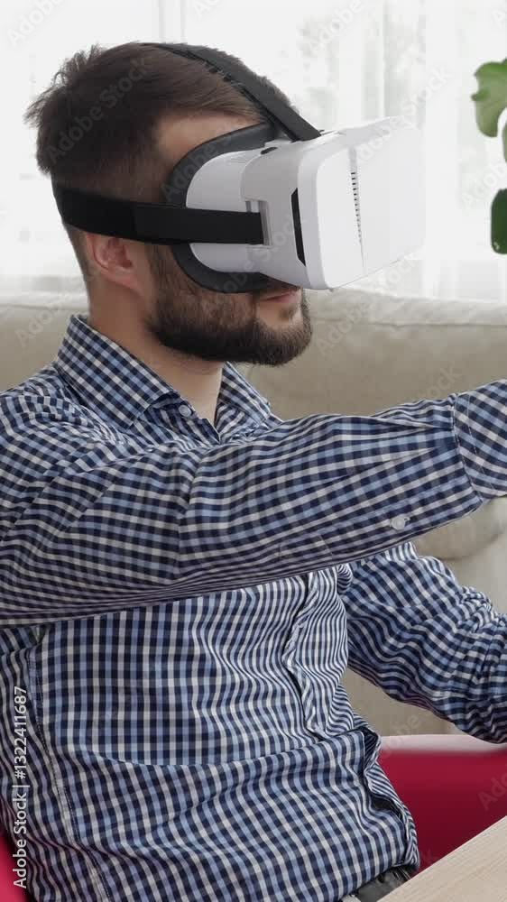 Positive Caucasian middle aged man working with VR headset at home. Concept of a futuristic technology and innovations. Vertical video. Positive Caucasian middle aged man working with VR headset at home. Concept of a futuristic technology and innovations. Vertical video.