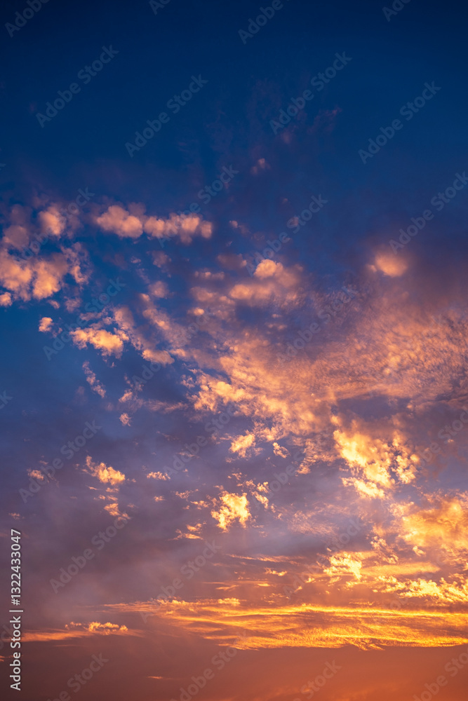 Fototapeta premium Stunning dramatic sunset sky with golden clouds and blue and purple texture