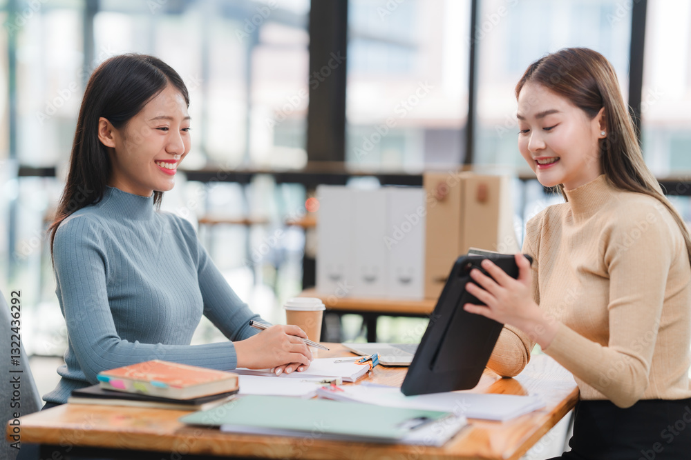 Two Asian Businesswomen Collaborating on Tablet Two Asian Businesswomen Collaborating on Tablet