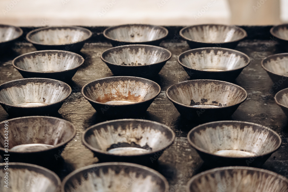 Empty pastry molds before baking pasteis de nata in Lisbon, a famous Portuguese dessert Empty pastry molds before baking pasteis de nata in Lisbon, a famous Portuguese dessert