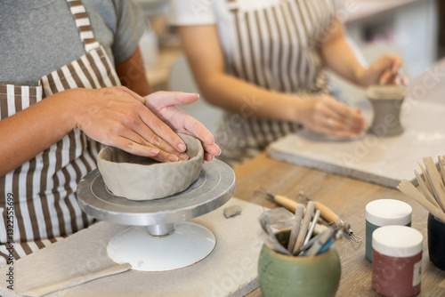 Canvas Print Female hands sculpting product from raw clay in ceramic workshop close-up