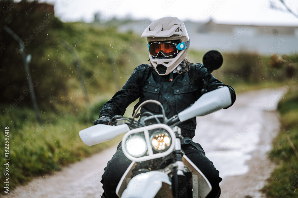 Motorista creando contenido en dia lluvioso en camino de barro inundado