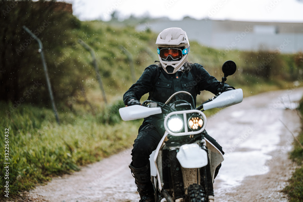 Motorista creando contenido en dia lluvioso en camino de barro inundado