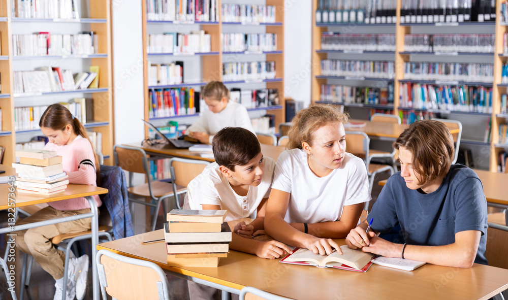 Smart teenagers spending time in library together and doing their homework. Smart teenagers spending time in library together and doing their homework.