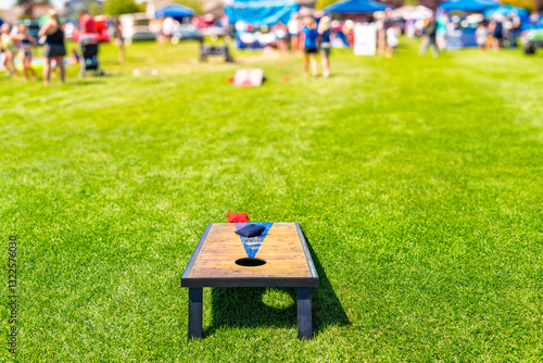 Fototapeta Naklejka Na Ścianę i Meble -  The lawn game of Cornhole, with two boards and fabric bean bags filled with corn at an outdoor family festival on a sunny day.