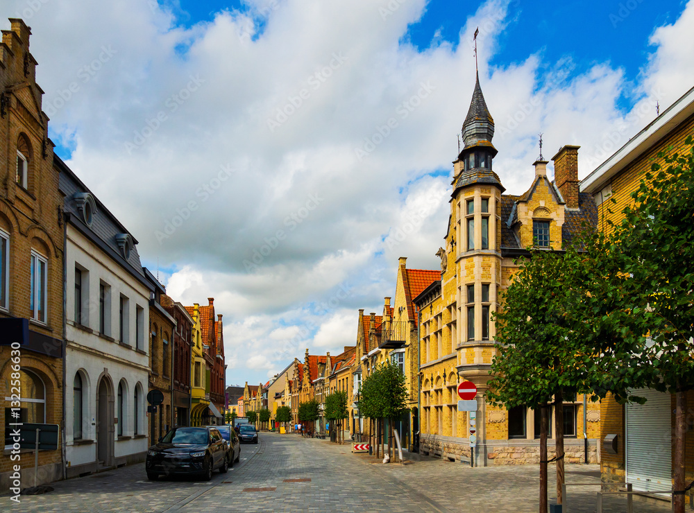 Fototapeta premium Picturesque view of Diksmuide street with typical residential buildings on sunny summer day, Belgium.