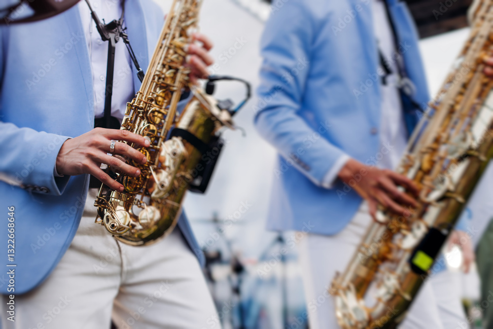 Fototapeta premium Concert view of saxophonist musician, saxophone sax player with vocalist and musical band during jazz orchestra show performing music on a stage in the scene lights, concert in a musical club hall